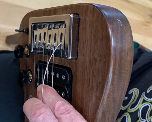 Put finger under string to get correct string tension